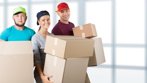 Mover wearing PPE while lifting furniture safely